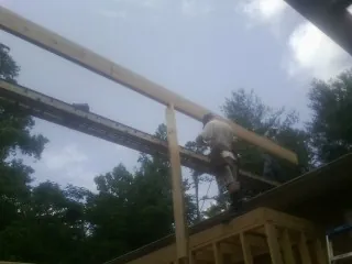 Carpenter setting a ridge beam over a new addition frame — Ice Dam Removal by Roofing Brothers in Linkwood