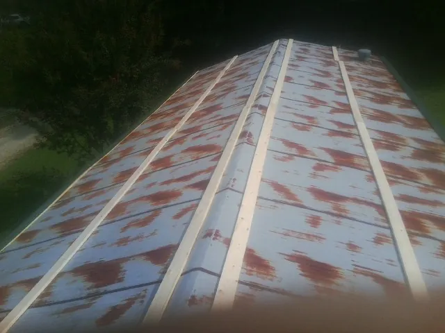 Rusted metal roof panels with new wood purlins before replacement — Storm Damage Roof Repair in Linkwood by Roofing Brothers