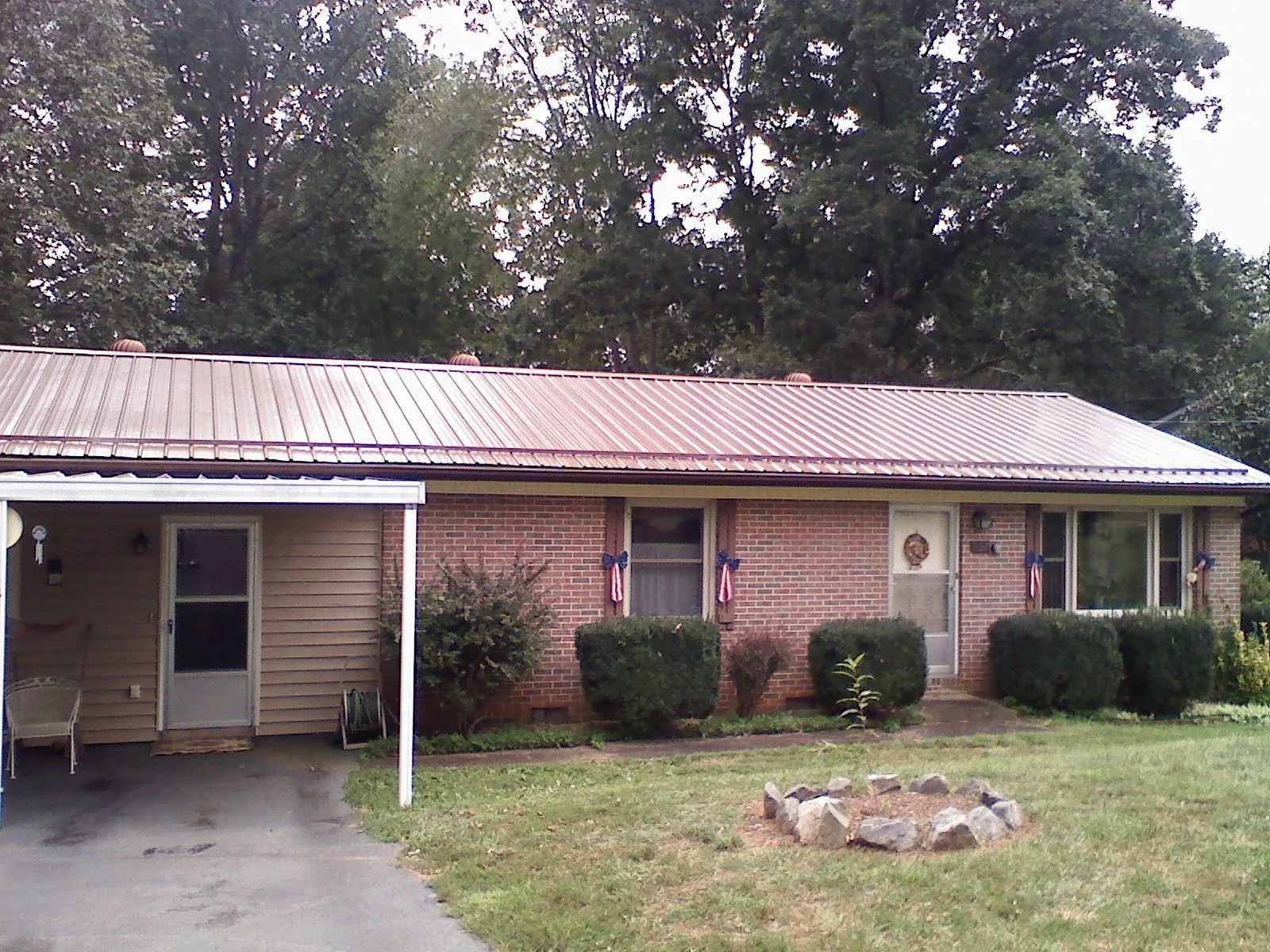 Bronze metal roof and carport on a brick ranch home — Roof Repair work by our crew in Linkwood